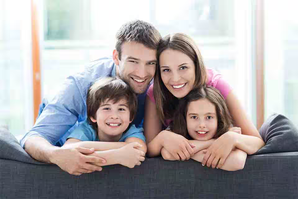 Family smiling on couch